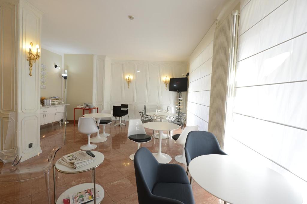 a room with tables and chairs and a kitchen at Hotel Tourist in Turin