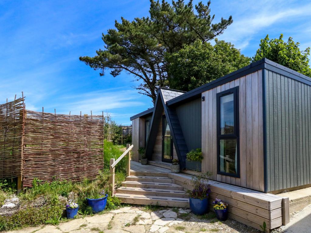 a small house with a wooden fence and stairs at The Cabin in Swanage