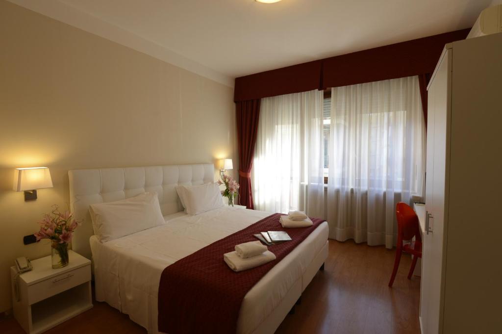 a bedroom with a large bed with two towels on it at Hotel Tourist in Turin