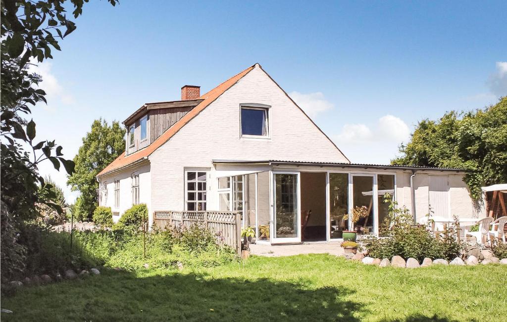 a white house with a porch and a yard at Two-Bedroom Holiday Home Thyholm With Sea View 04 in Thyholm