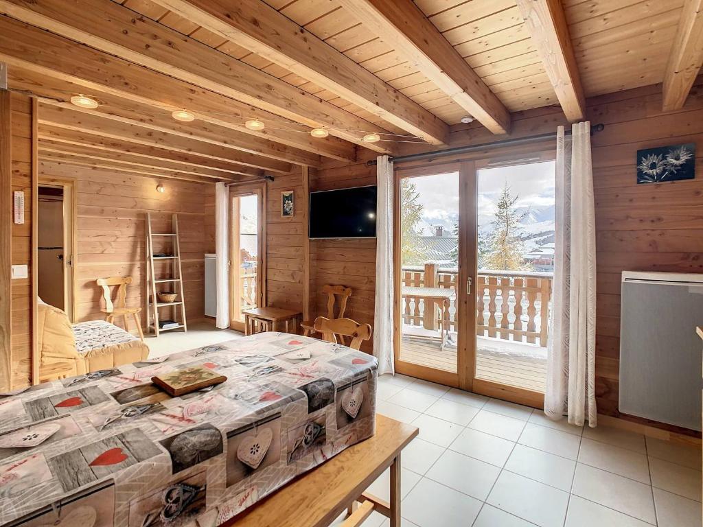 Un dormitorio con una cama grande y un balcón. en Chalet cosy 2 étoiles, 9 pers, 4 ch, 2 sdb, terrasse sud, proche télésiège, commerces, piscine été - FR-1-417-5, en La Toussuire