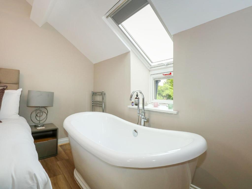 a white bathroom with a sink and a window at Daisy's Place in Fakenham