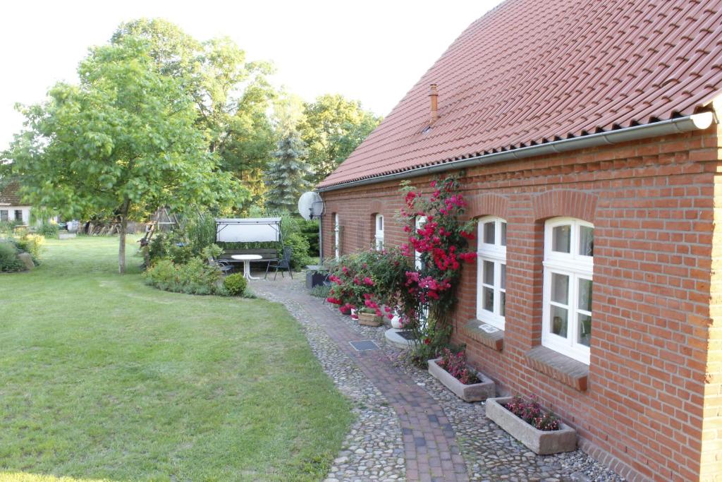 a red brick house with a garden and a bench at Damwildhof Blievenstorf- Ferienhaus in Blievenstorf