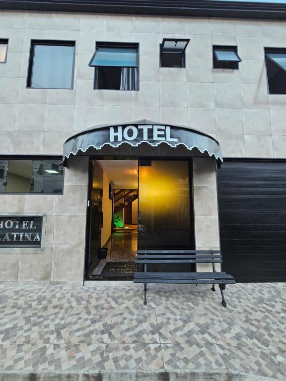 a hotel with a bench in front of a building at Hotel Platina in Juiz de Fora