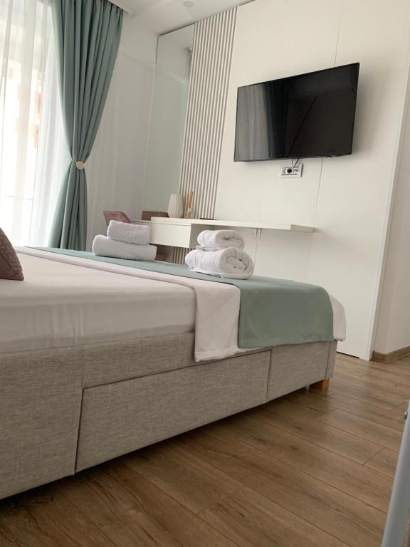 ein Schlafzimmer mit einem Bett mit einem Flachbildfernseher an der Wand in der Unterkunft Anda3 in Mamaia