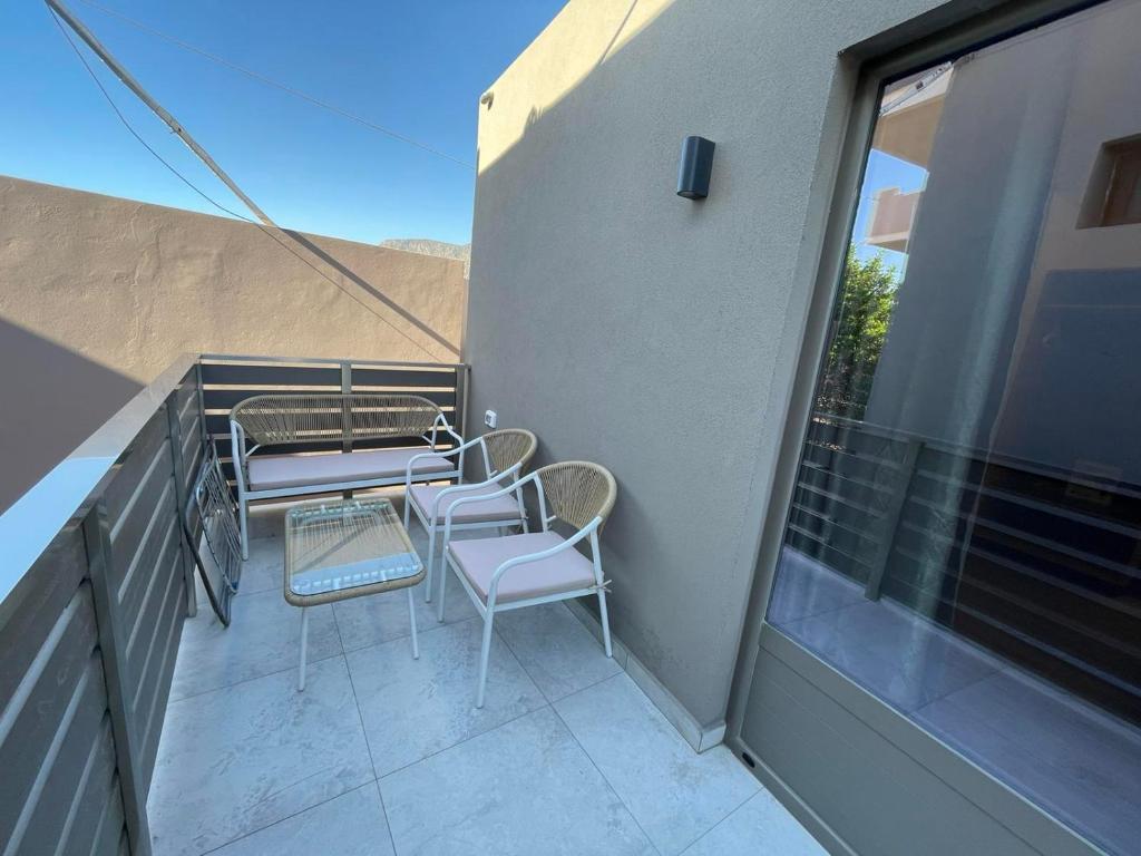 a balcony with chairs and tables on a building at Elafonisi Paradise with Parking, WiFi, - Walking Distance to the Beach in Elafonisi