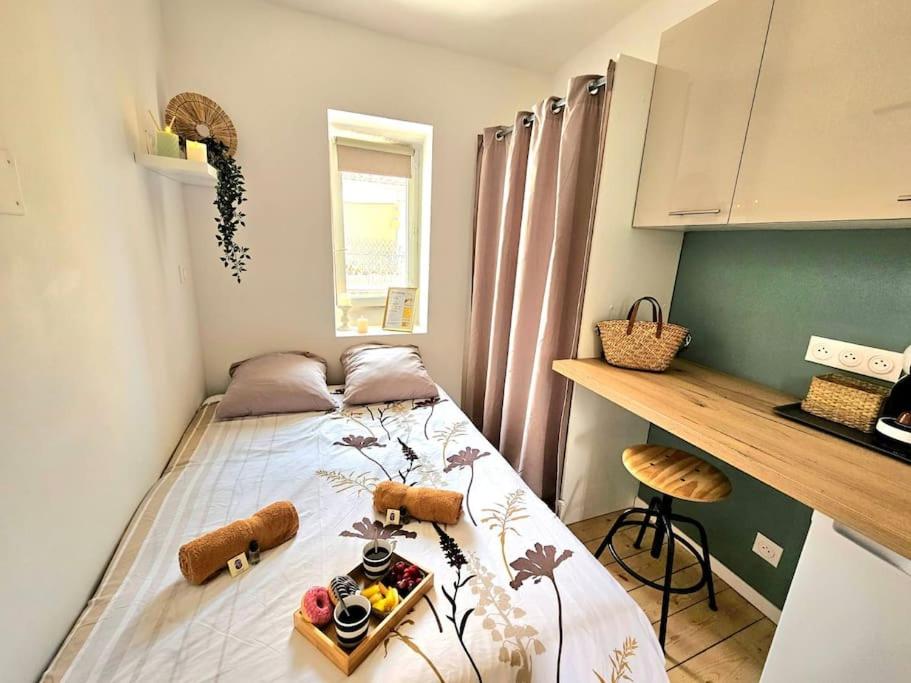 - une chambre avec un lit et un plateau de nourriture dans l'établissement le nido -studette - clim - coeur de ville, à Nîmes
