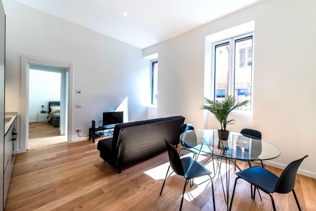 a living room with a glass table and a couch at Appartamento Vittoria in Legnano