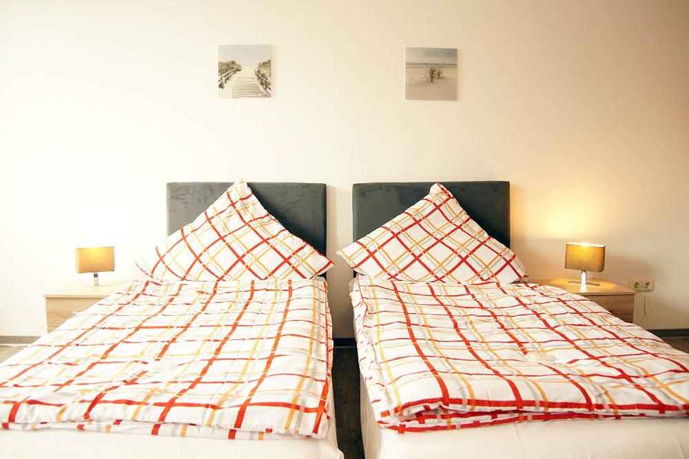 two beds sitting next to each other in a bedroom at Pensione da Vito in Greifswald