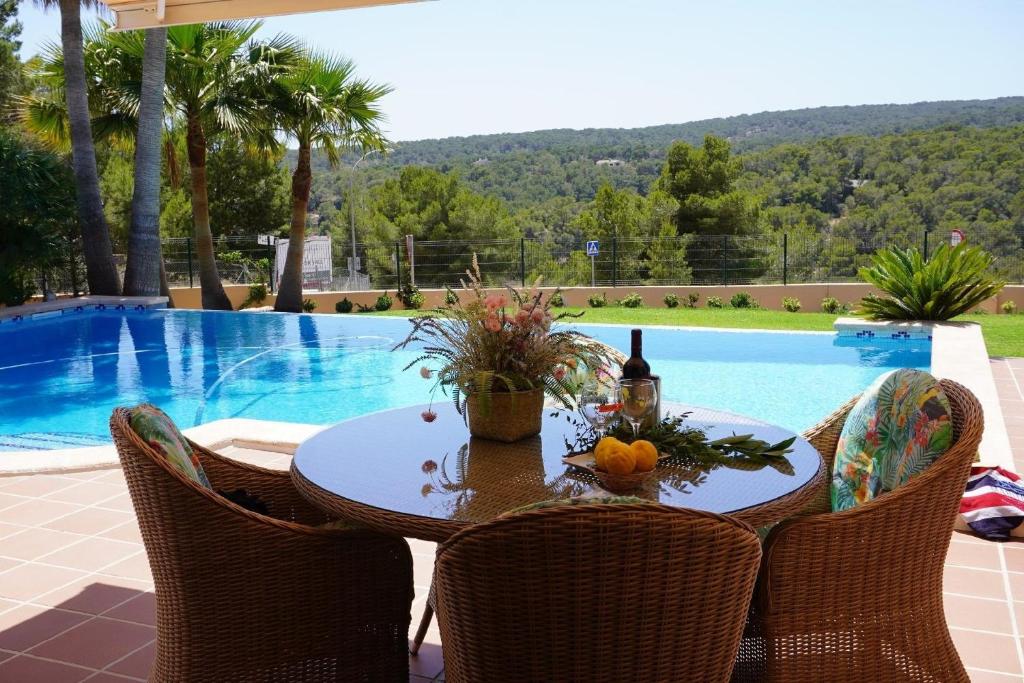 a table and chairs next to a swimming pool at Villa Sol de Mallorca in Sol de Mallorca