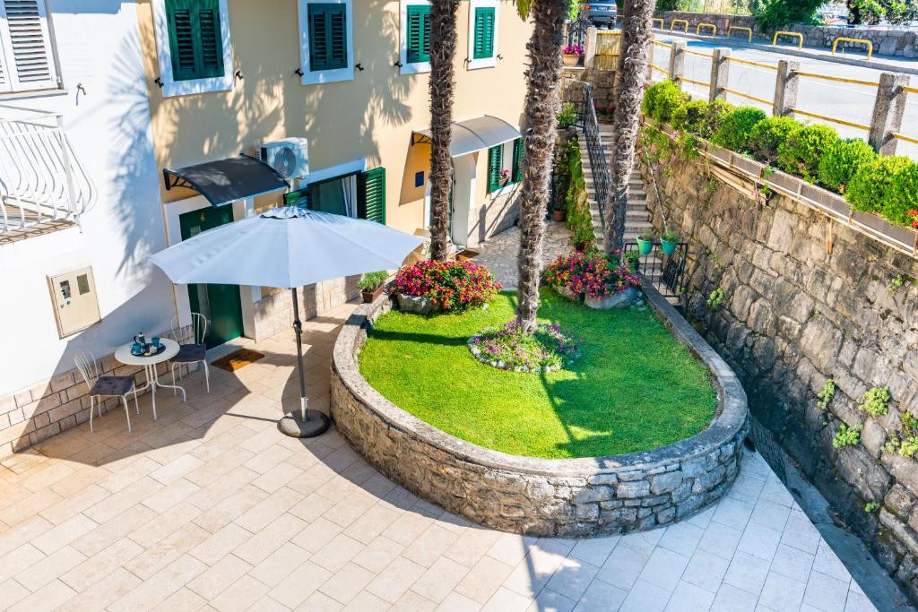 a patio with an umbrella next to a building at Studio apartment Ičići by the sea in Ičići