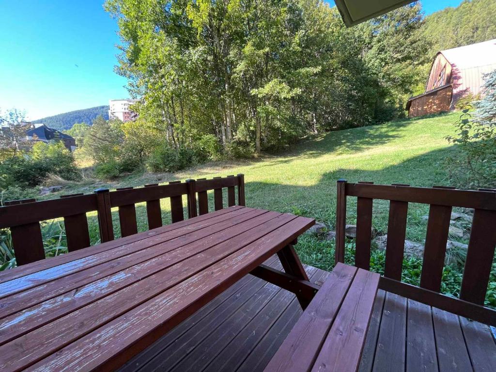 un banc en bois installé au-dessus d'une terrasse dans l'établissement Charmant studio aux Molanès, Uvernet-Fours, idéal pour les skieurs, très confortable pour 2 personnes - FR-1-165A-173, à Uvernet