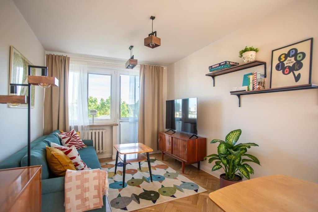 a living room with a blue couch and a tv at ODPOCZINK 2-pokojowe mieszkanie w centrum in Gdynia