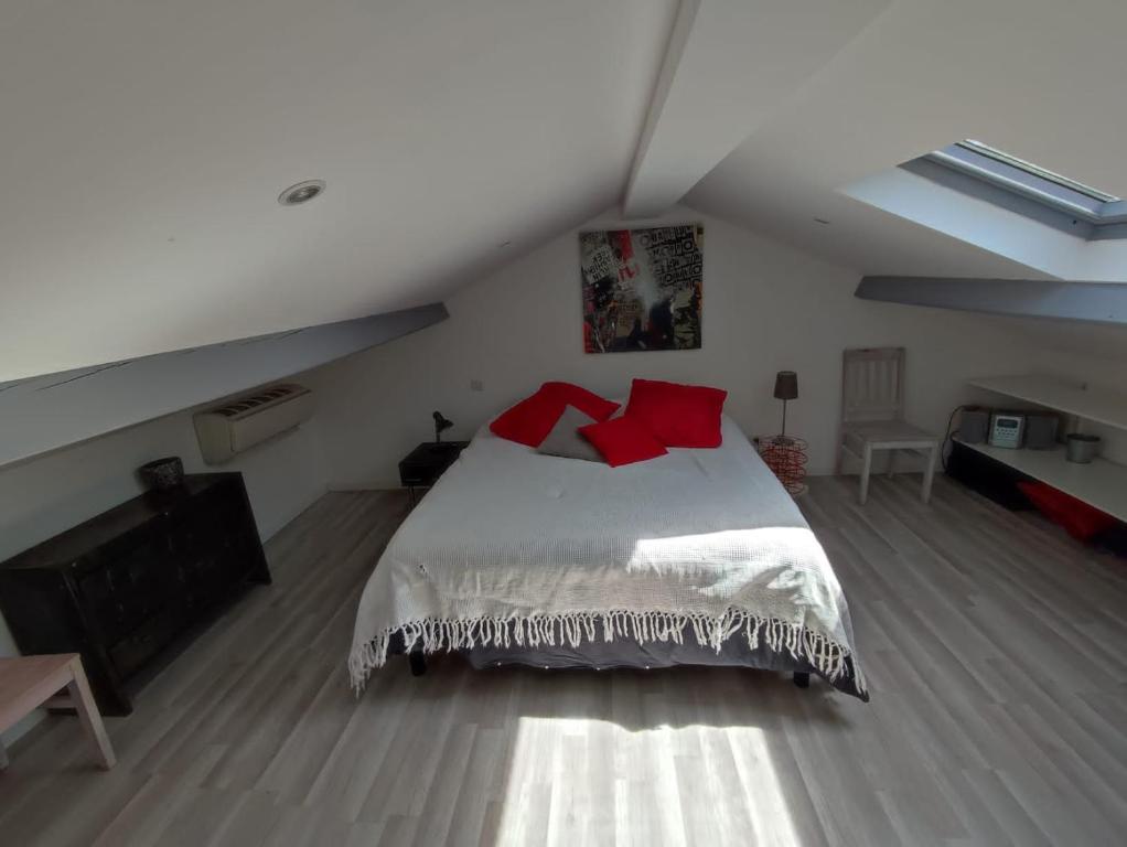 - une chambre avec un lit doté d'oreillers rouges dans l'établissement Villa Serendip proche du lac, à Lacanau