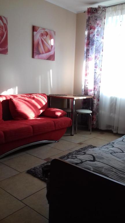 a living room with a red couch and a table at Pokoje u Ani in Zastań