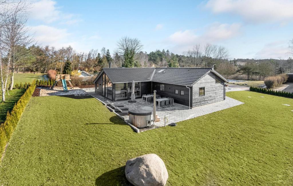 a large yard with a house with a playground at Cozy Home In Ebeltoft With Sauna in Ebeltoft