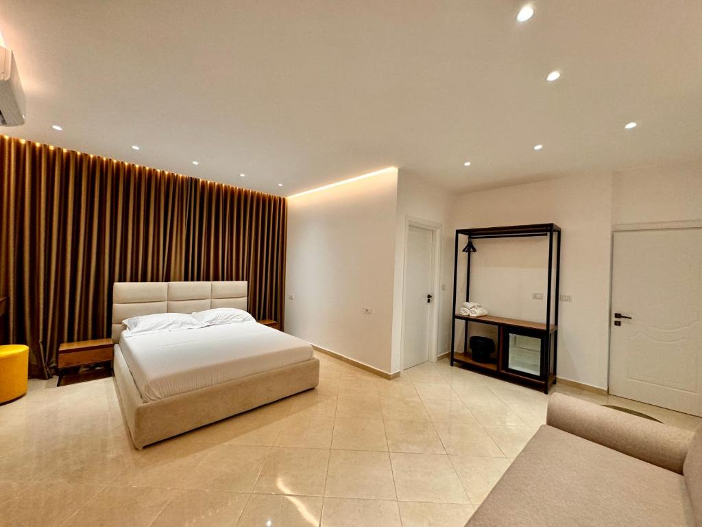 a bedroom with a bed and a large window at Dine Hotel in Ksamil