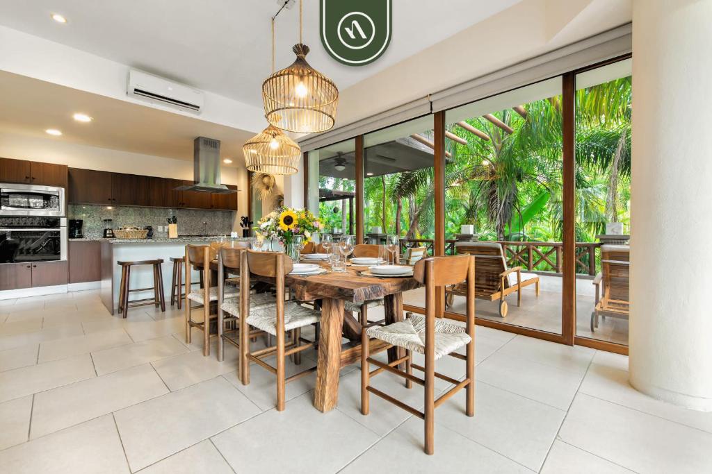 Una cocina y un comedor con mesa y sillas de madera. en Haixa A107, en Higuera Blanca