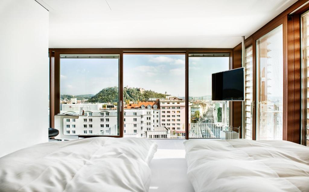1 dormitorio con cama grande y ventana grande en Hotel Daniel Graz - Smart Luxury Near City Centre, en Graz