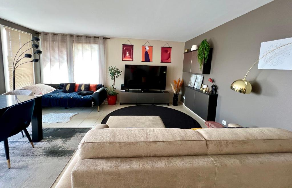 un salon avec un canapé et une télévision dans l'établissement Appartement climatisé 3 étoiles T3 chic à Strasbourg avec billard et terrasse, à Strasbourg
