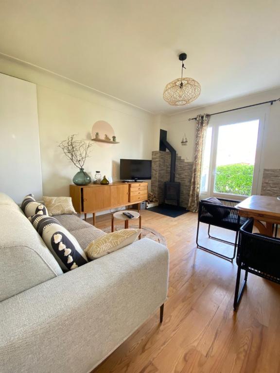 un salon avec un canapé et une table dans l'établissement Petite maison de vacances, à Oloron-Sainte-Marie