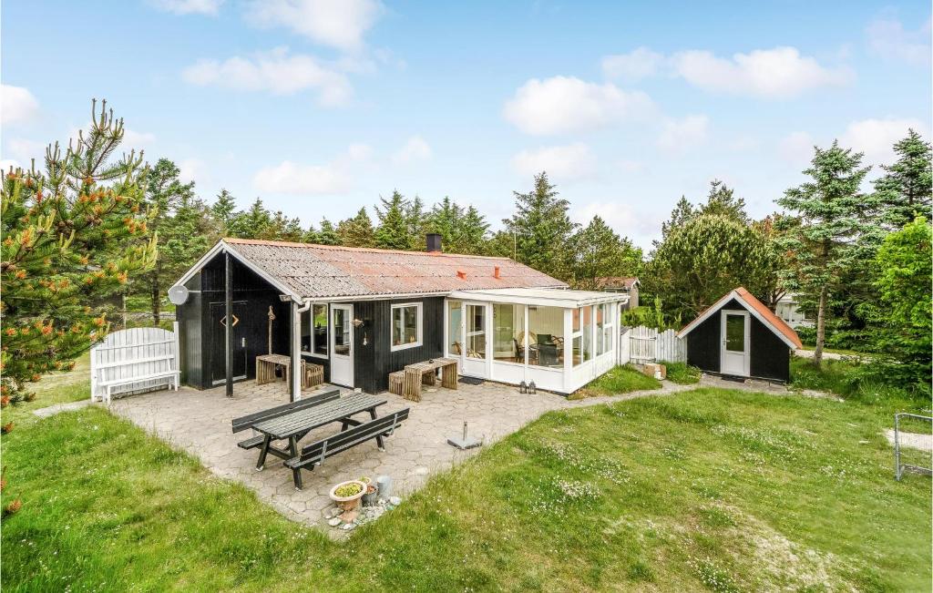 a small black and white house with a picnic table at Holiday Home Mølgårdsvej Thisted in Sønder Vorupør