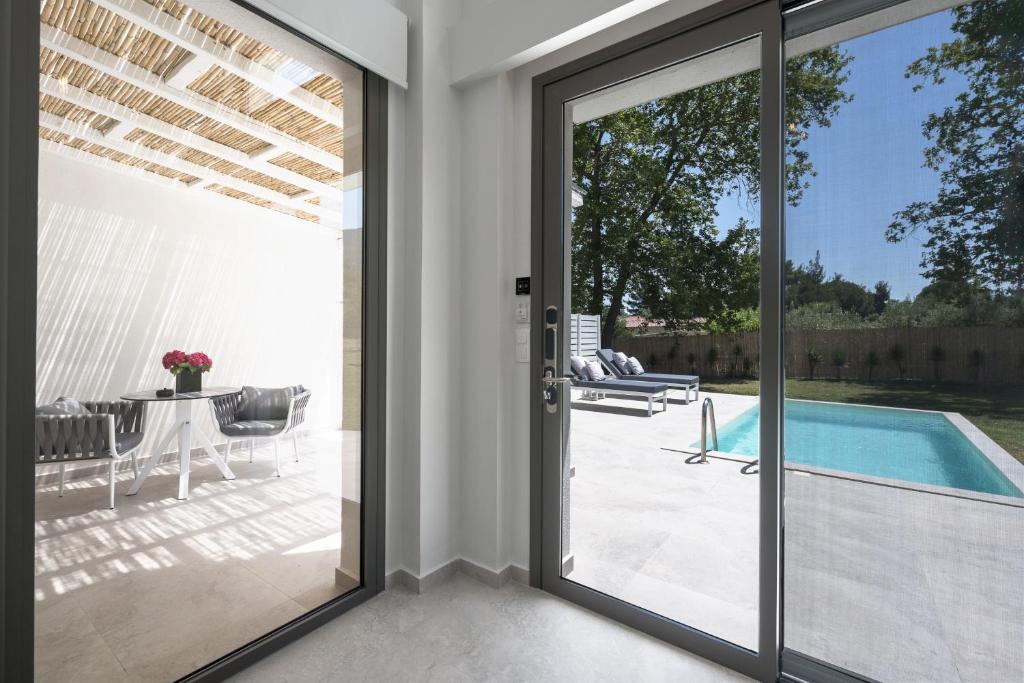 a sliding glass door leading to a patio with a pool at Astrum Luxury Suites in Vourvourou