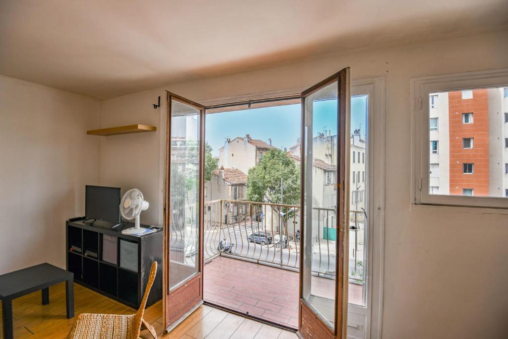 Il comprend un salon doté d'une grande fenêtre et d'un balcon. dans l'établissement Bail mobilité - Studio avec balcon proche Timone, à Marseille