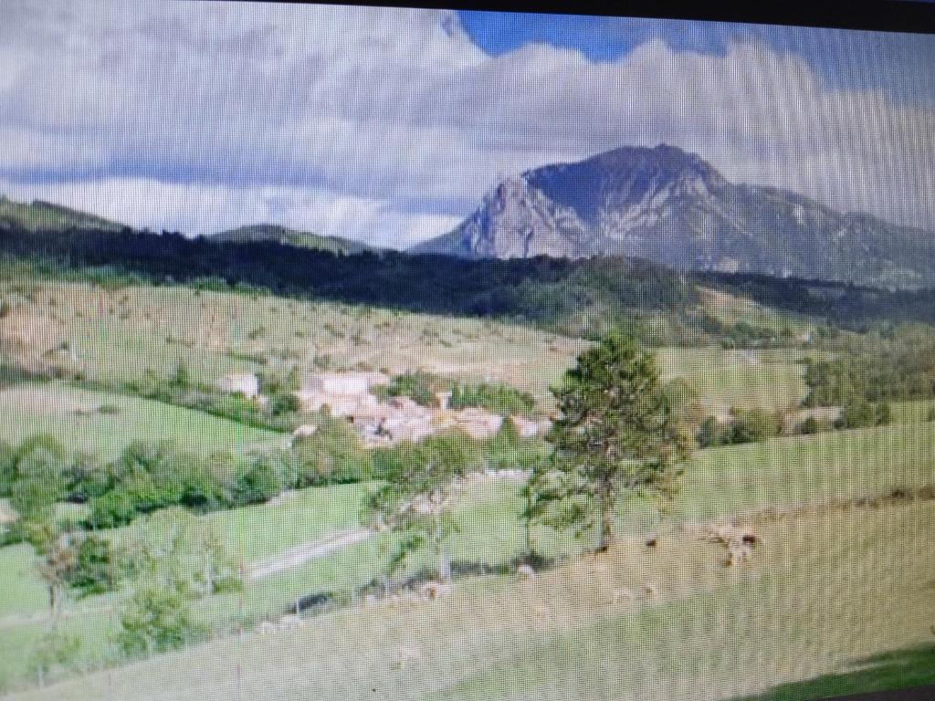 une vue sur un champ avec une montagne en arrière-plan dans l'établissement Maison de village avec jardin, à Saint-Louis-et-Parahou