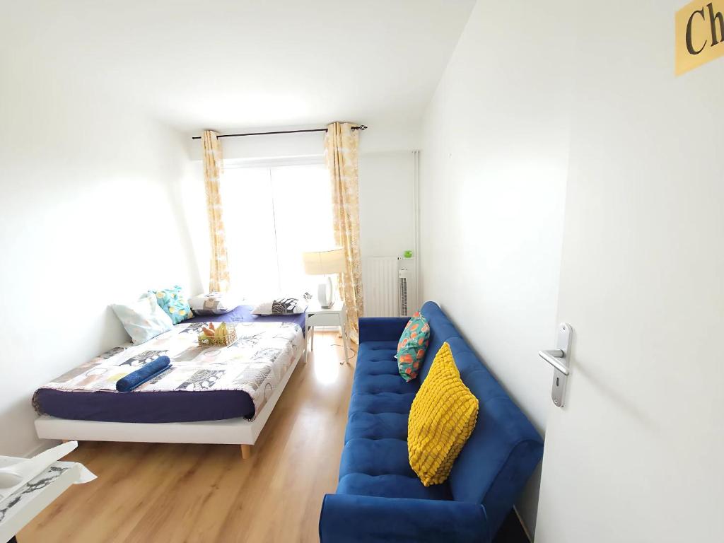 une chambre avec un lit et un canapé bleu dans l'établissement 5 Star Beautiful Premuim Appartment, Évry-Courcouronnes