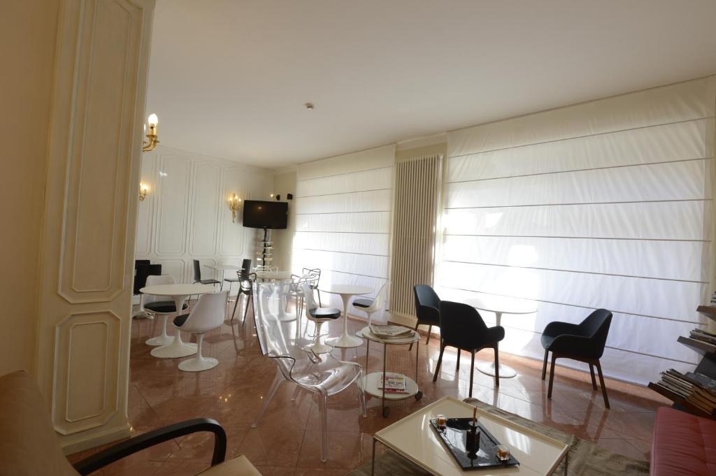 a living room with chairs and tables in a room at Hotel Tourist in Turin