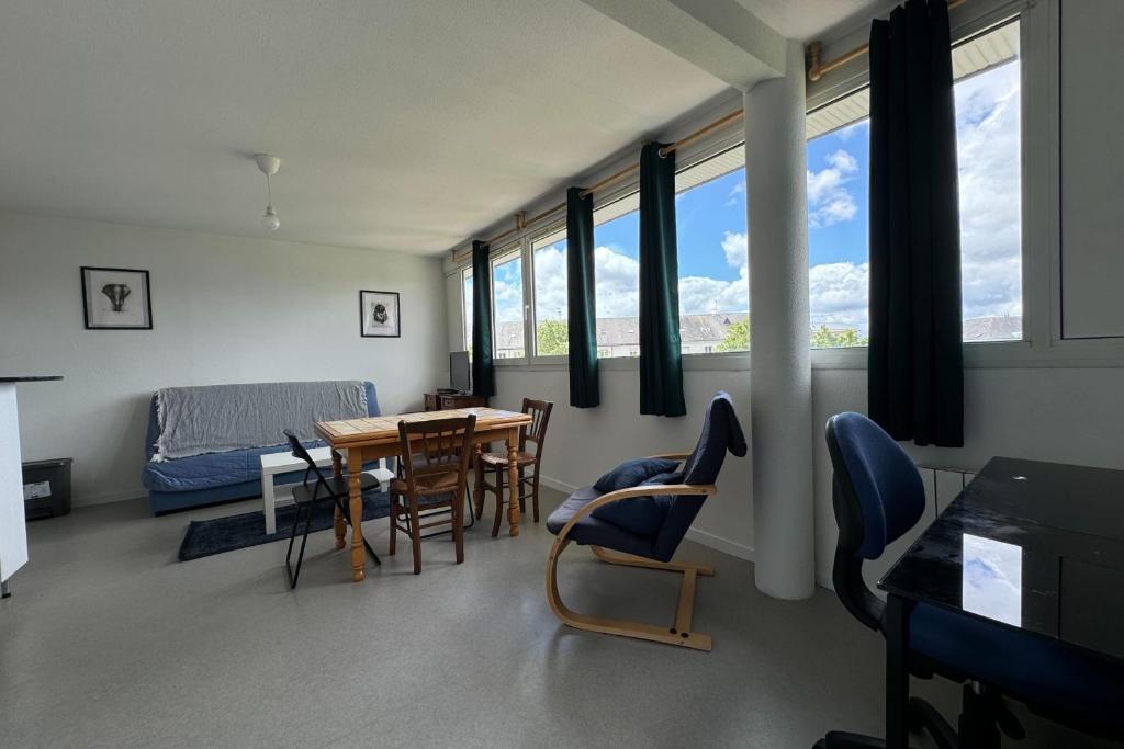 un salon avec une table, des chaises et des fenêtres dans l'établissement Nice T2 in the heart of Caen, à Caen