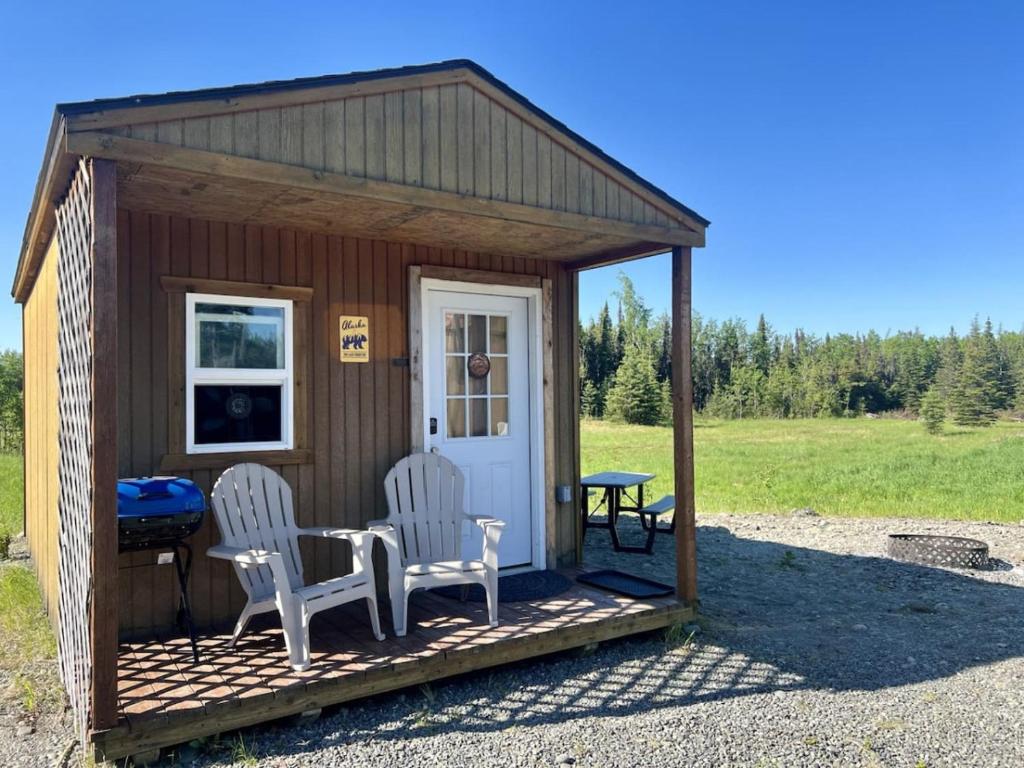 un piccolo capanno con due sedie e un tavolo di Grayling Bunkhouse at Red-Bow a Sterling