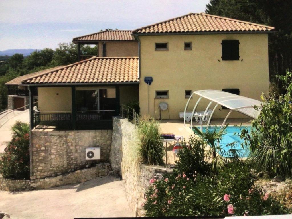 une maison avec une piscine devant dans l'établissement Le chêne vert, à Saint Alban Auriolles