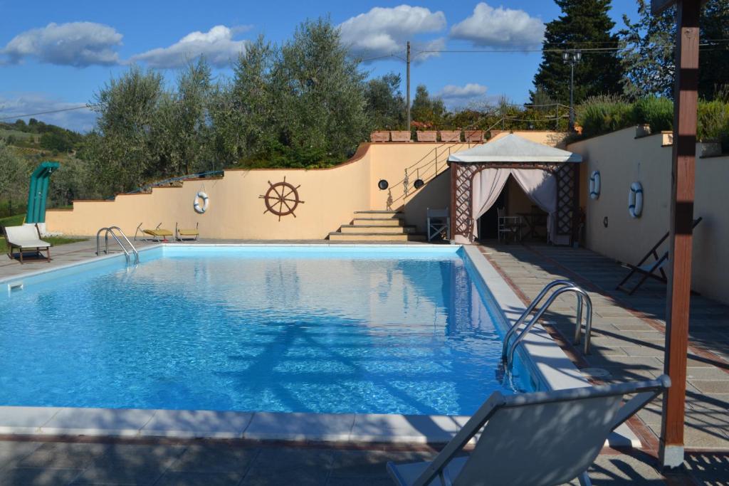 a swimming pool with a gazebo next to a house at Turignano Apartment in Montespertoli