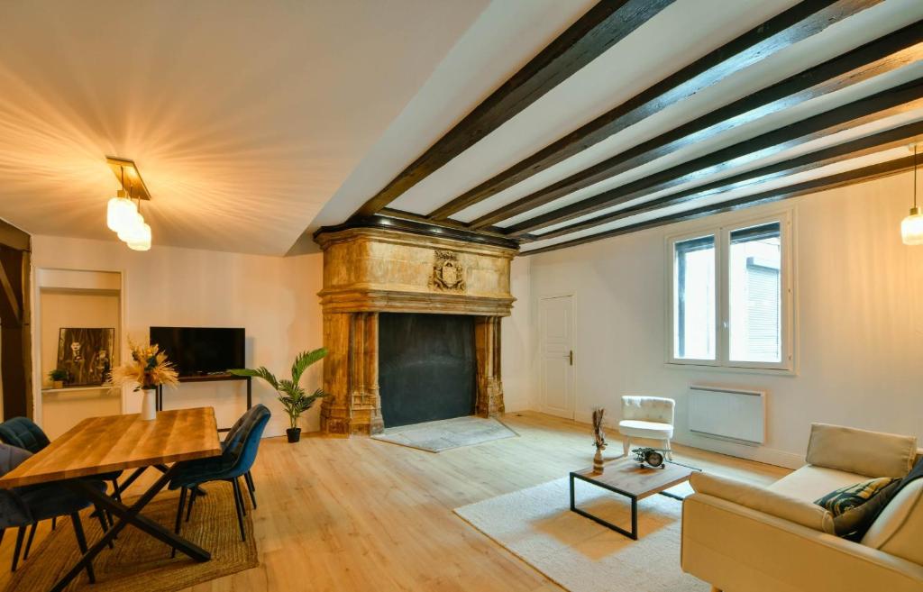 a living room with a fireplace and a table at La Dame Blanche - Appartement hypercentre historique - Parking privé in Bourges