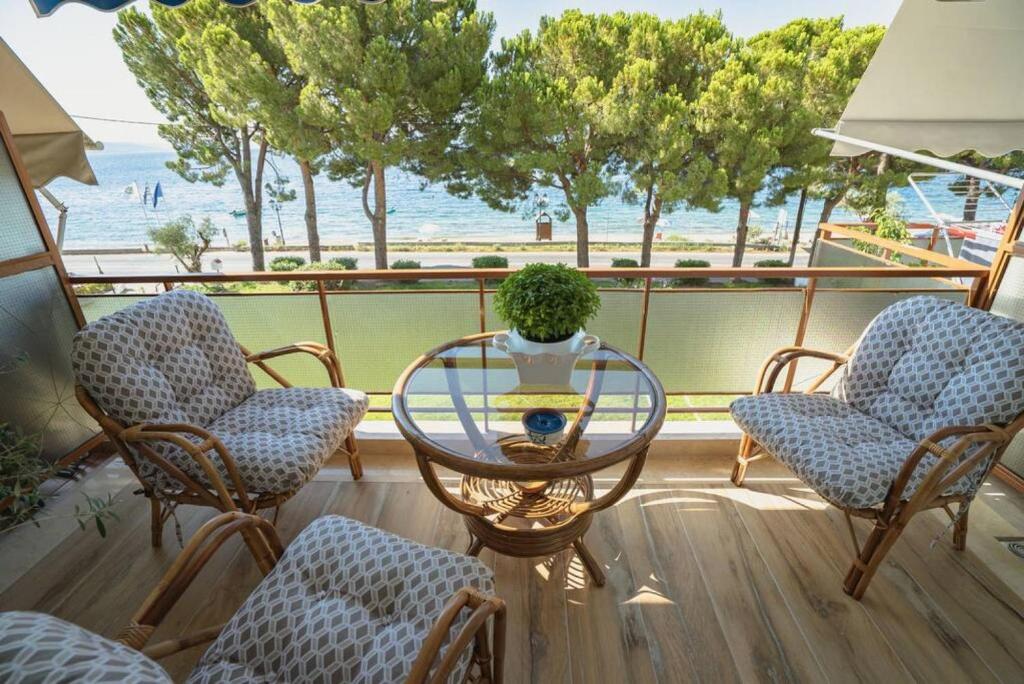 balkon ze stołem i krzesłami oraz widokiem na ocean w obiekcie Fili's Cozy Place in Malaki w mieście Malaki