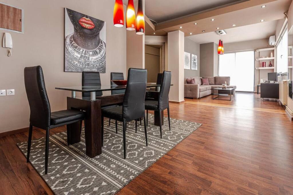 a living room with a dining room table and black chairs at Casa Anna Maria in Volos in Volos