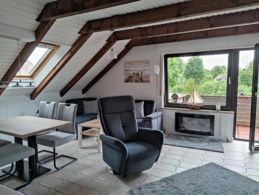 ブットヤーディンゲンにあるGesamte Wohnung in Burhaveのリビングルーム(テーブル、椅子、暖炉付)