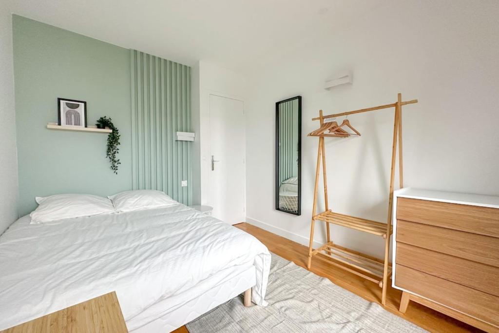 une chambre avec un lit et une commode dans l'établissement Flexliving - room - Hillairet, à Paris