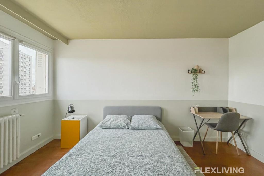 ein Schlafzimmer mit einem Bett, einem Schreibtisch und einem Stuhl in der Unterkunft Flexliving - room - Losserand in Paris