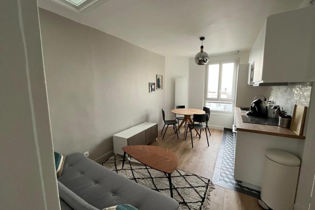 un salon avec un canapé et une table dans l'établissement Flexliving - room - Caulaincourt, à Paris