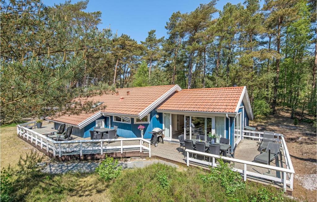une petite maison bleue avec une grande terrasse dans l'établissement Holiday Home Mejsevej Nexø Ii, à Spidsegård