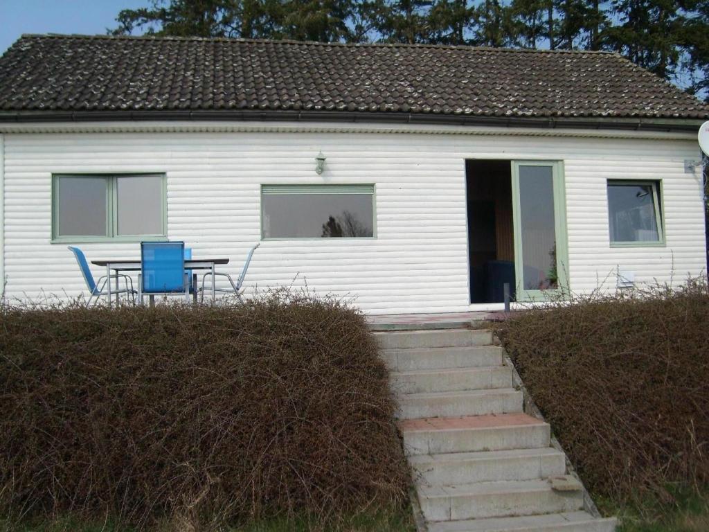 a white house with a table and chairs in front of it at Ein Chalet mit großem Garten und Panoramablick in Rochefort