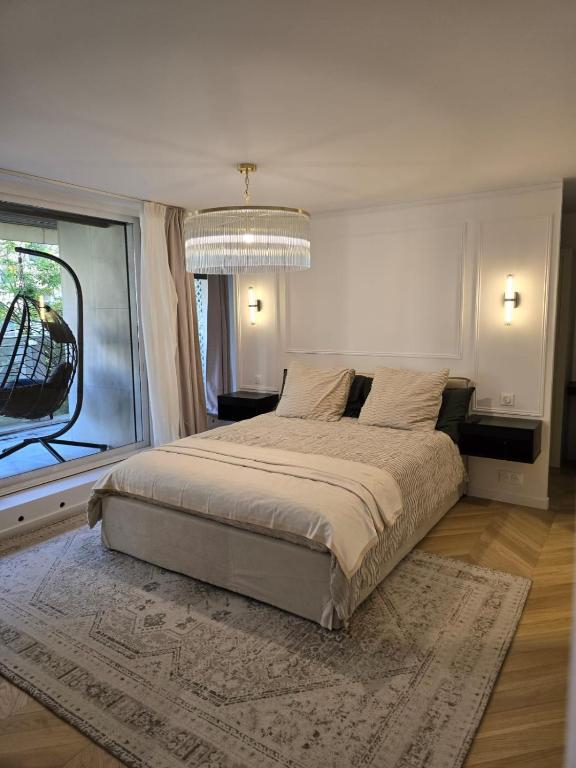 une chambre avec un grand lit et une grande fenêtre dans l'établissement Henri martin, vue Tour Eiffel Trocadéro luxe et chic, à Paris