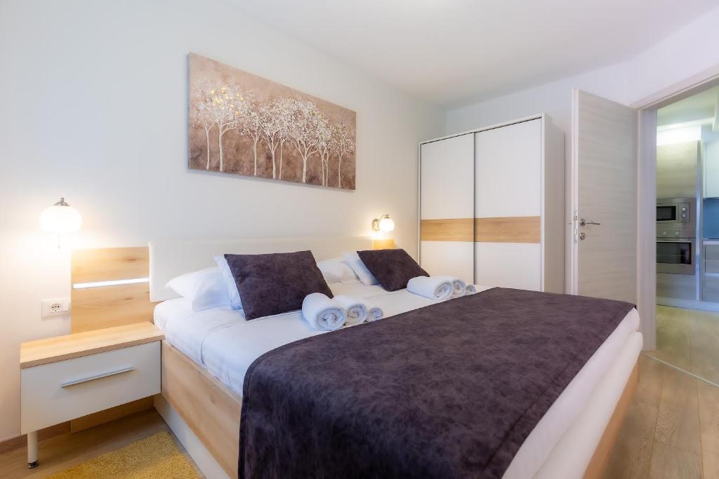 a bedroom with a large bed with two pillows at Apartman ANGOLO VERDE in Vižinada