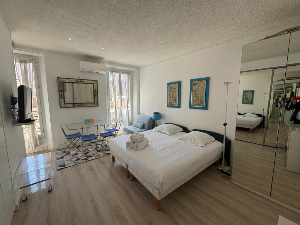 une chambre avec un grand lit blanc dans une pièce dans l'établissement Studio Cannes Carré d'Or, à Cannes