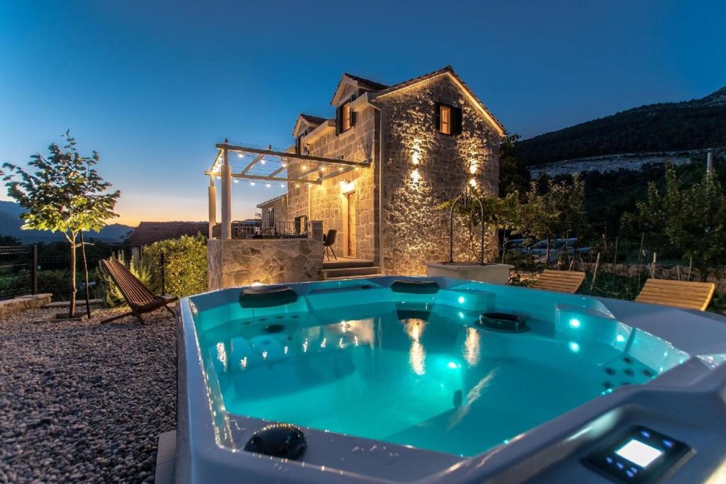 a hot tub in front of a stone house at Villa Le Adria - Privat HotTub - Kostenloser Strandparkplatz in Kozica