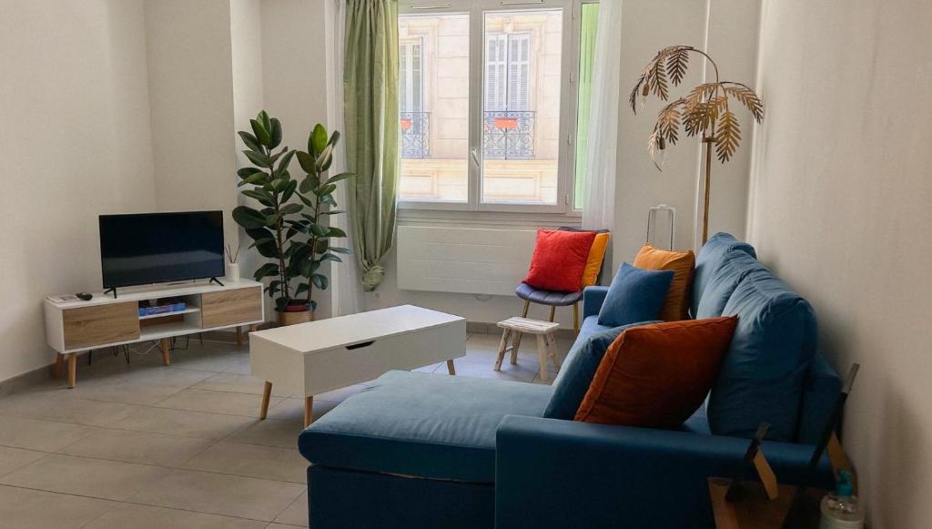 a living room with a blue couch and a tv at Appartement près de la gare St Charles in Marseille