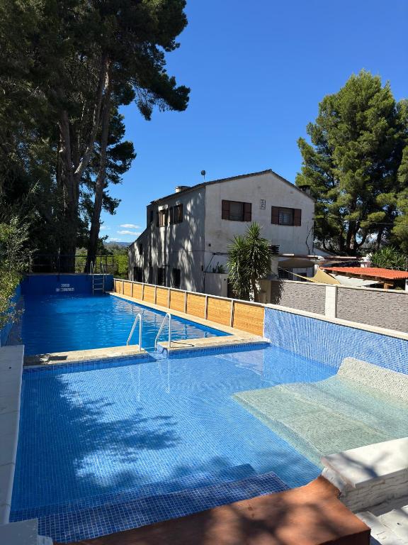 a swimming pool with blue water in front of a building at MASIA LA MOLINERA in Xerta